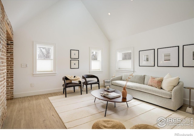 living room featuring high vaulted ceiling and light wood-type flooring