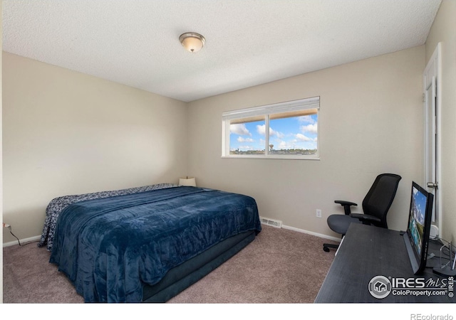 bedroom with light carpet and a textured ceiling