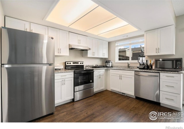 kitchen featuring dark hardwood / wood-style flooring, stone countertops, stainless steel appliances, and white cabinetry