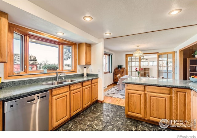 kitchen featuring a textured ceiling, stainless steel dishwasher, and sink