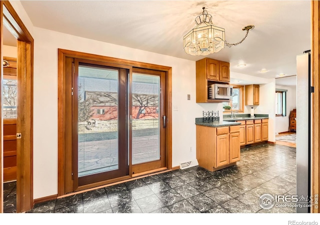 kitchen with sink, hanging light fixtures, and an inviting chandelier