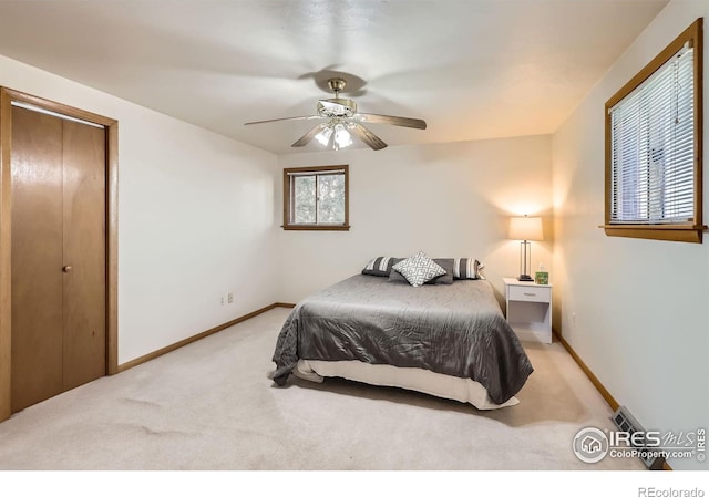 carpeted bedroom featuring ceiling fan and a closet