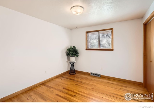 unfurnished room with hardwood / wood-style flooring