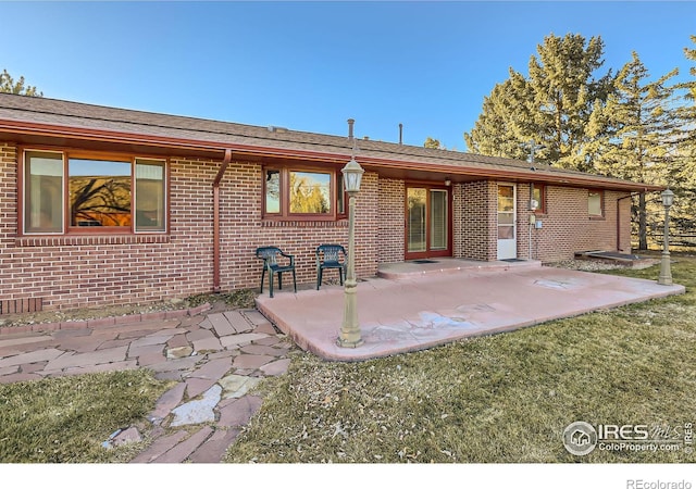 back of property with a patio area and a lawn