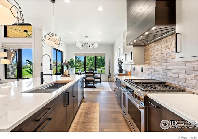 kitchen with decorative light fixtures, custom exhaust hood, sink, appliances with stainless steel finishes, and dark brown cabinets