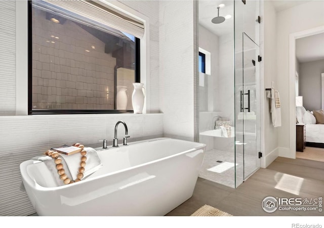 bathroom featuring tile walls and plus walk in shower