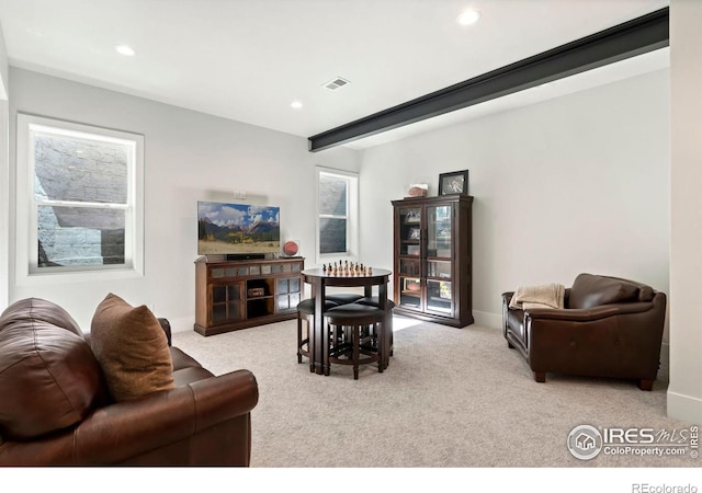 living room featuring beam ceiling and light colored carpet