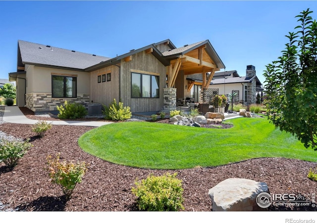 rear view of property featuring central AC unit and a yard