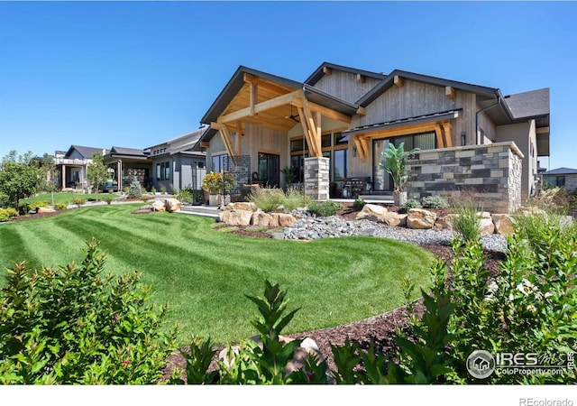 rear view of property with ceiling fan and a yard