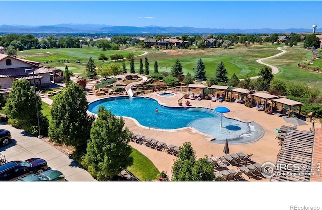 view of pool featuring a mountain view, a water slide, and a patio