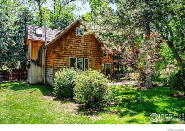 rear view of house featuring a yard