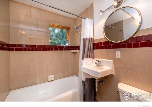 full bathroom with toilet, tile walls, shower / bath combination with curtain, and sink