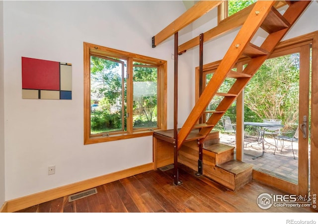 interior space with wood-type flooring and lofted ceiling with beams