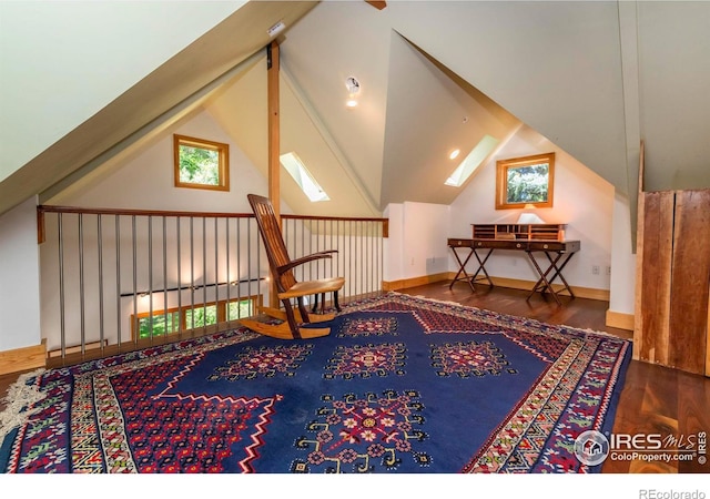 living area with vaulted ceiling with skylight and dark hardwood / wood-style floors