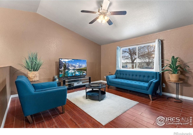 living room featuring ceiling fan, dark hardwood / wood-style flooring, and vaulted ceiling