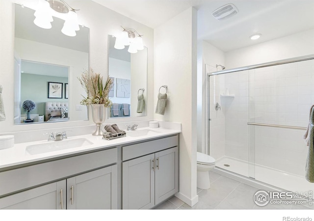 bathroom with tile patterned flooring, toilet, a shower with door, and vanity