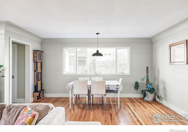 dining space with wood-type flooring and crown molding