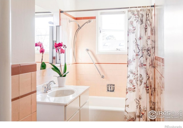 bathroom featuring a healthy amount of sunlight, shower / bath combo, and vanity