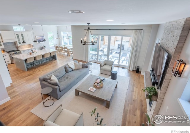 living room with a chandelier, light hardwood / wood-style flooring, and sink