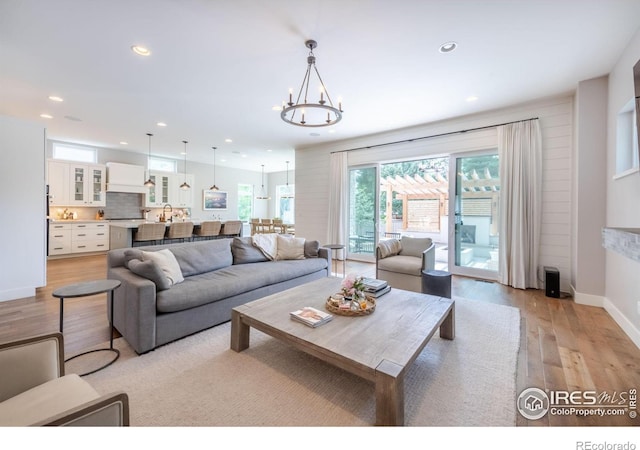 living room with light hardwood / wood-style flooring and a notable chandelier