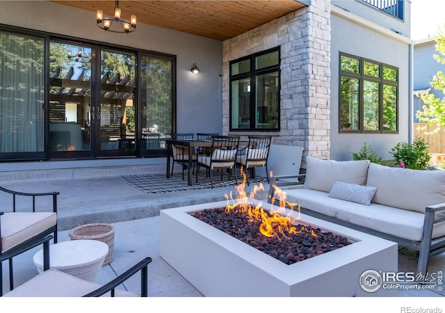 view of patio featuring an outdoor living space with a fire pit