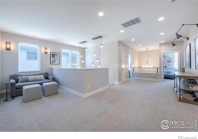 living room with light carpet and a notable chandelier