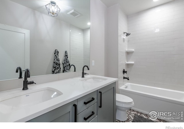 full bathroom with toilet, tiled shower / bath, and vanity