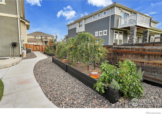 view of yard featuring a balcony and central air condition unit