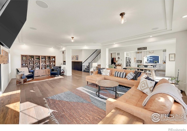 living room featuring crown molding and wood-type flooring