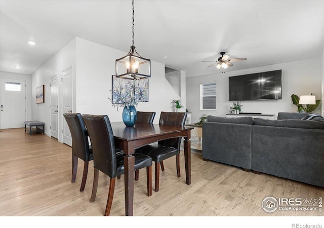 dining area featuring ceiling fan with notable chandelier and light hardwood / wood-style floors