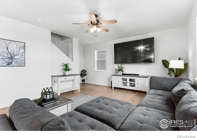 living room with ceiling fan and light hardwood / wood-style flooring