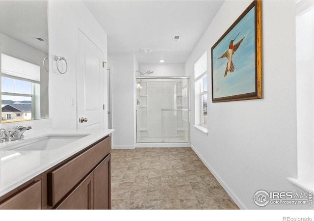 bathroom featuring vanity and a shower with door