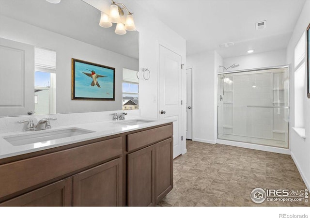 bathroom featuring a wealth of natural light, walk in shower, and vanity