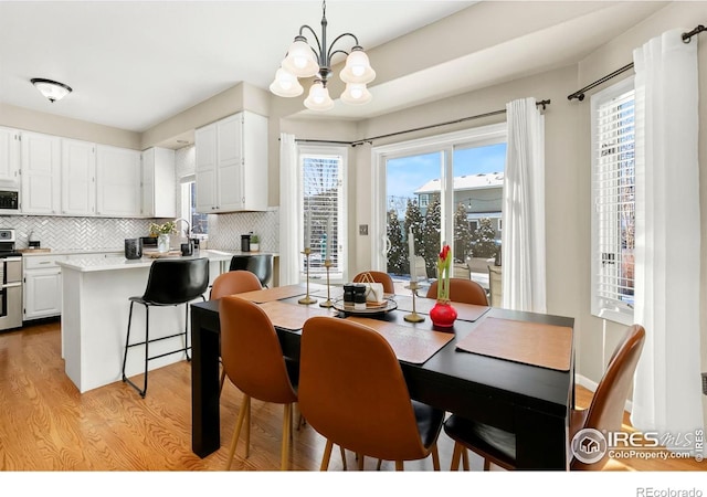 dining area featuring light hardwood / wood-style flooring and a notable chandelier