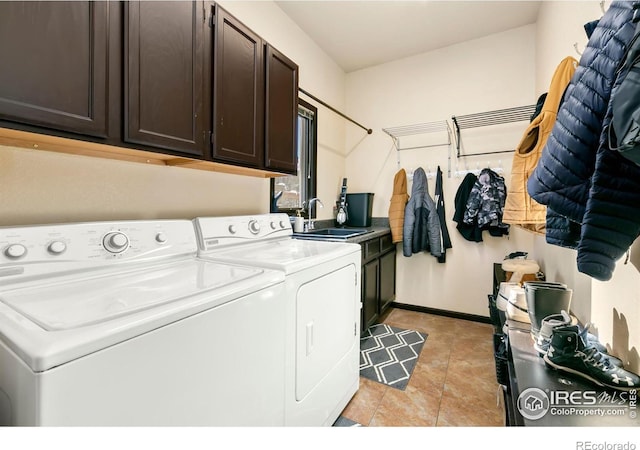 washroom with sink, cabinets, washing machine and clothes dryer, and light tile patterned flooring