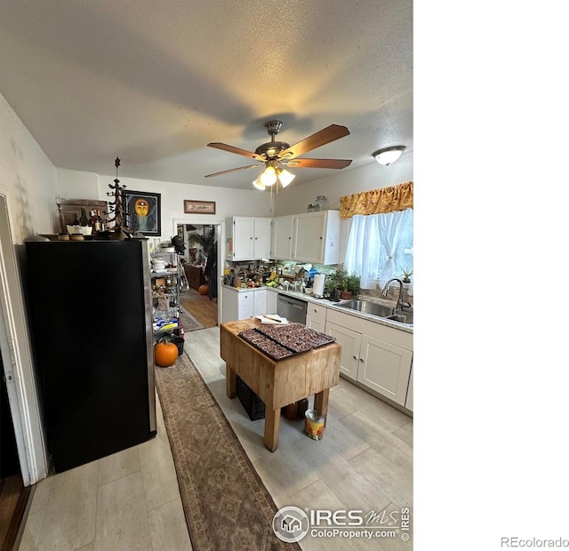 kitchen featuring sink, ceiling fan, stainless steel appliances, a textured ceiling, and white cabinets