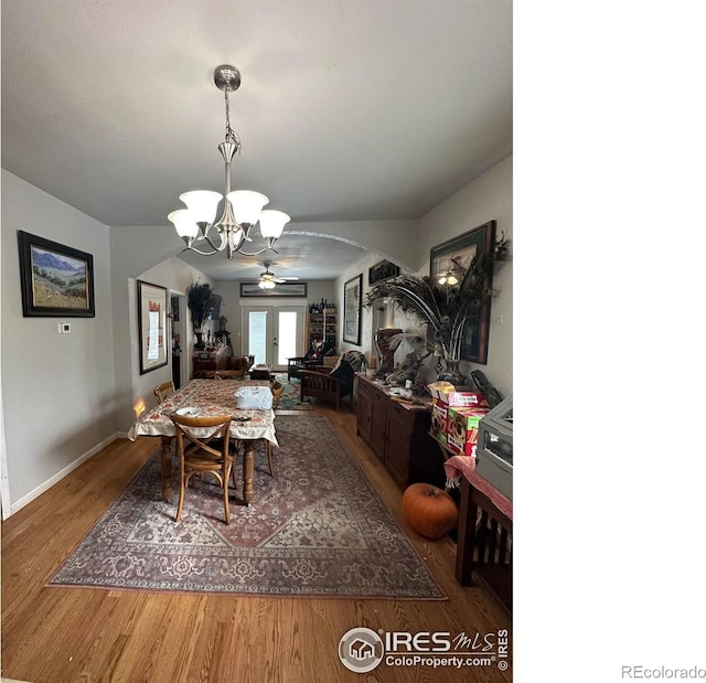 dining room with an inviting chandelier, hardwood / wood-style floors, and french doors