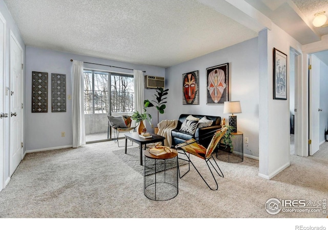 carpeted living room with a wall mounted AC and a textured ceiling