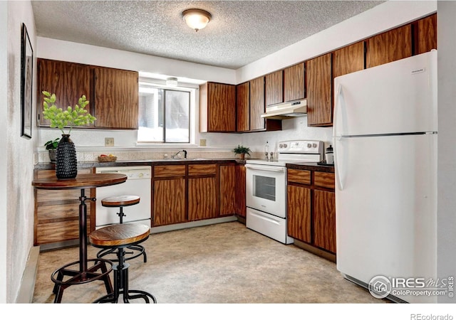 kitchen with sink, white appliances, and a textured ceiling