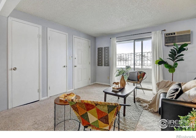 living room featuring a wall mounted AC, light colored carpet, and a textured ceiling