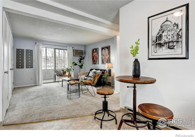 sitting room featuring carpet flooring, a textured ceiling, and an AC wall unit