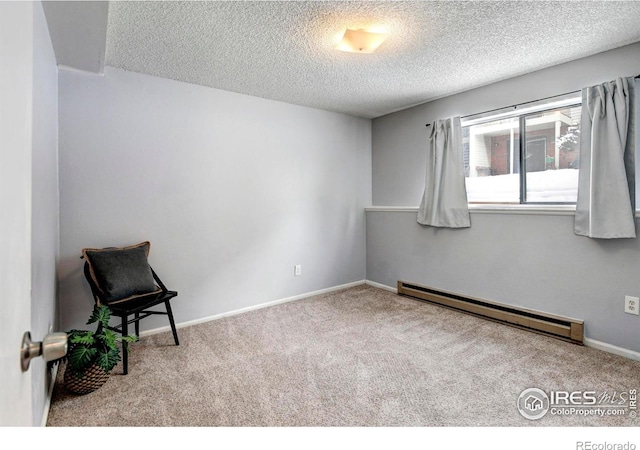 carpeted empty room with a textured ceiling and baseboard heating