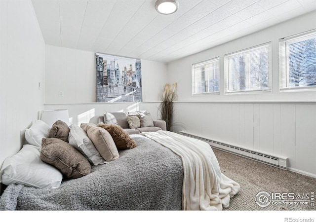 carpeted bedroom featuring a baseboard heating unit