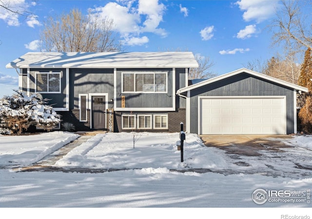 split foyer home featuring driveway, brick siding, and an attached garage