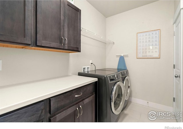 clothes washing area featuring light tile patterned flooring, cabinets, and independent washer and dryer