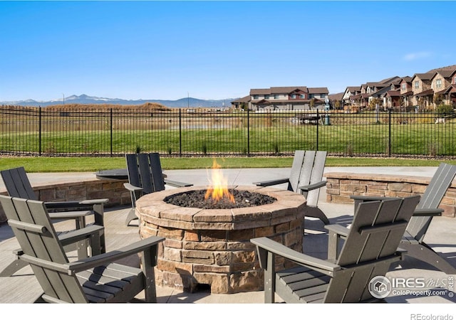 view of patio with a mountain view and an outdoor fire pit