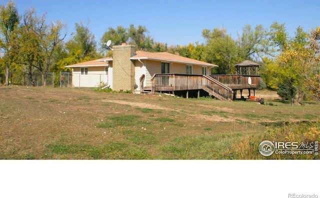 rear view of property with a wooden deck and a gazebo