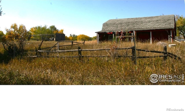 view of yard featuring an outdoor structure and a rural view