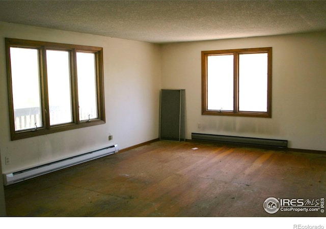 unfurnished room with a textured ceiling and a baseboard heating unit