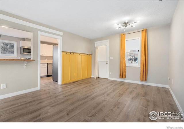 unfurnished room featuring hardwood / wood-style flooring and a textured ceiling